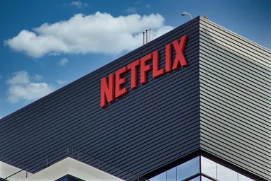 Nahaufnahme eines modernen Netflix-Bürogebäudes mit großem roten Netflix-Logo auf dunkler, gestreifter Fassade