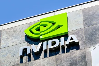 NVIDIA logo displayed on a building facade with a bright green sign and metallic lettering against a clear blue sky