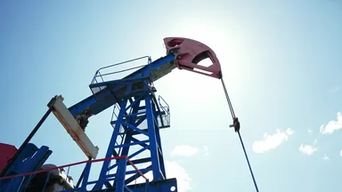 Ölpumpe (Pumpjack) fördert Rohöl unter blauem Himmel – Symbol für Energieproduktion und Ölmarkt.