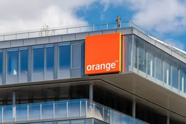 Logo Orange affiché sur l'angle d'un immeuble de bureaux moderne
