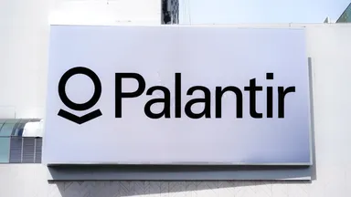 Palantir logo displayed on a large white sign on a building exterior.