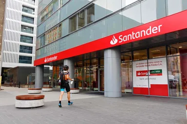 Exterior of a Santander bank branch displaying the company logo on a modern office building, representing the international banking and financial services group. 