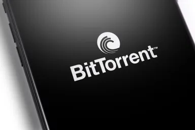 Nahaufnahme eines Smartphone-Bildschirms, der das BitTorrent-Logo vor schwarzem Hintergrund zeigt.