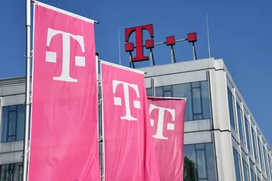 Deutsche Telekom flags and logo displayed on a modern office building exterio