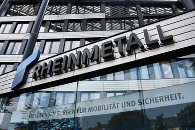 Rheinmetall company logo displayed on the facade of a modern office building with glass windows