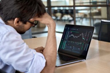 A trader looks at his laptop with concern.