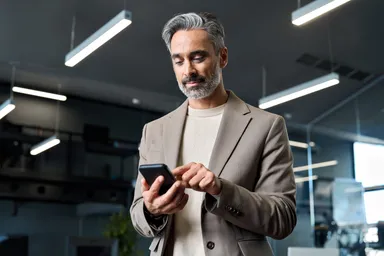 Man using a smartphone in a modern office.