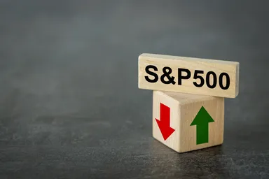 Simbolo S&P 500 su blocchi di legno con frecce che indicano movimenti al rialzo e al ribasso