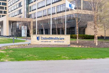 UnitedHealthcare office building exterior with company sign and flag displayed in front of the headquarters.”
