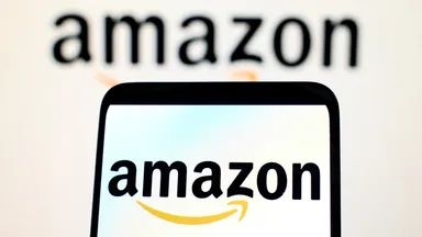 Amazon logo displayed on a smartphone screen with a blurred Amazon logo in the background