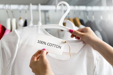 Cotton clothing on a rail being examined by a shopper