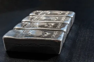 Stack of silver bullion bars arranged on a dark surface