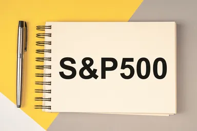 Notebook with “S&P 500” text placed on a desk next to a pen