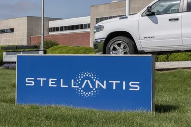 Stellantis company sign in front of a building with a pickup truck visible above it
