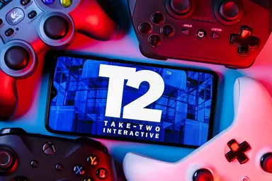 Take-Two Interactive Logo auf einem Smartphone-Bildschirm, umgeben von Gaming-Controllern