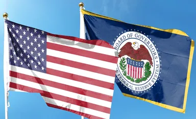 US-Flagge neben der Flagge der Federal Reserve – Symbol für Geldpolitik und US-Wirtschaft