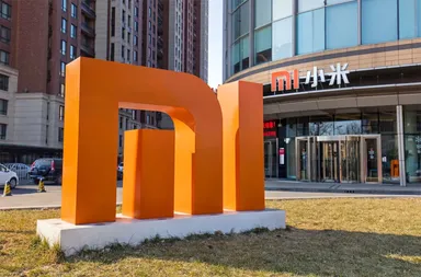 Xiaomi-Logo-Skulptur vor einem modernen Bürogebäude