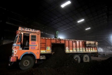 A file photo of a worker shoveling coal in a supply truck at a yard on the outskirts of Ahmedabad, India, October 25, 2018. 