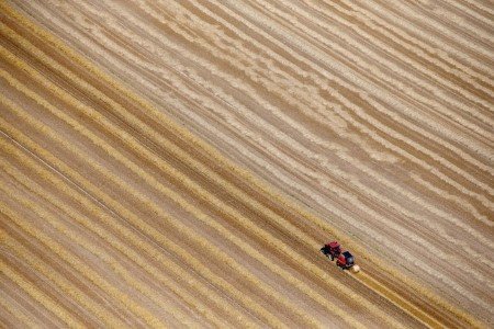 A file photo shows an aerial view of a French farmer in his tractor making bales of straw in a field in Coquelles,France, July 21, 2015. 