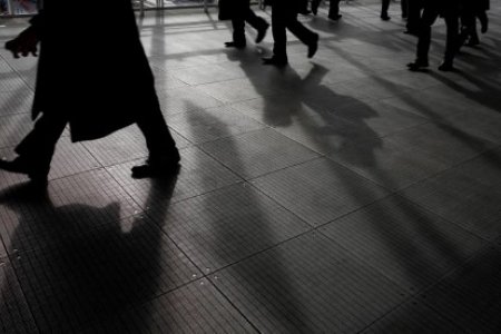 A file photo of pedestrians' shadows cast on the ground at an access aisle in Tokyo December 21, 2012.