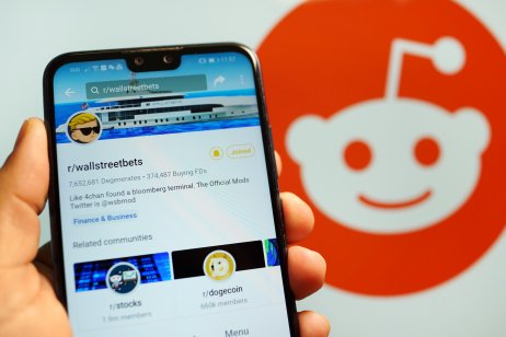 Phone screen showing the WallStreetBets forum in front of the Reddit logo