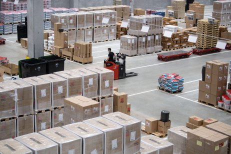 Employee drives a forklift truck in a warehouse