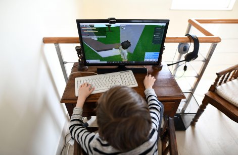 Young boy playing Roblox on a computer