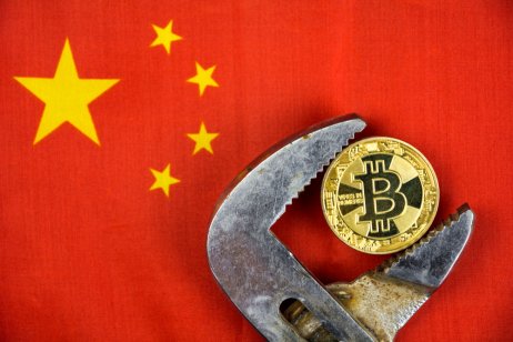 Bitcoin held in vice against background of China's flag