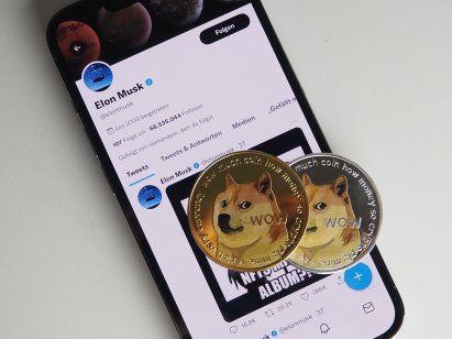 Dogecoins rest on a smartphone displaying Twitter