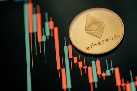 A gold Ethereum coin on a price chart