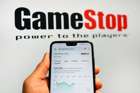 GameStop stock chart shown on a smartphone next to company logo