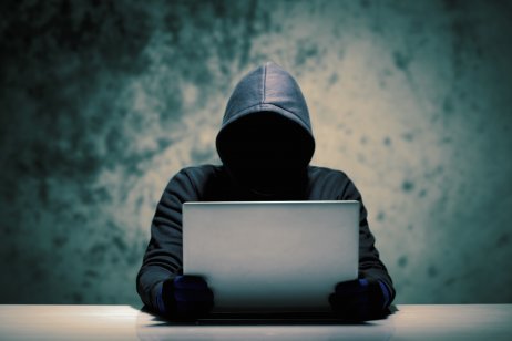 Computer hacker holding a laptop
