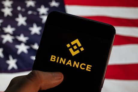 In this photo illustration the cryptocurrency exchange trading platform Binance logo is seen on an Android mobile device with United States of America flag in the background