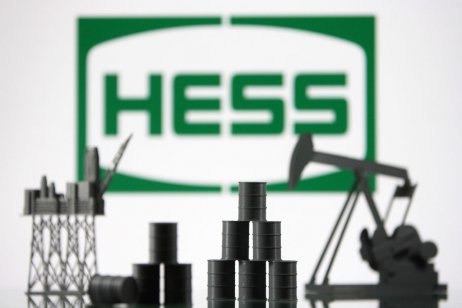 Hess Corporation logo and models of an oil rig,and oil barrels are pictured in and illustration