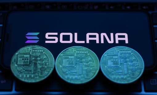 Solana logo displayed on a phone screen with representation of cryptocurrencies