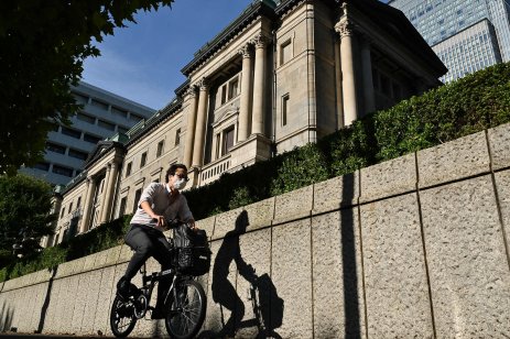 A man bicycles past the Bank of Japan headquarters buildings in Tokyo