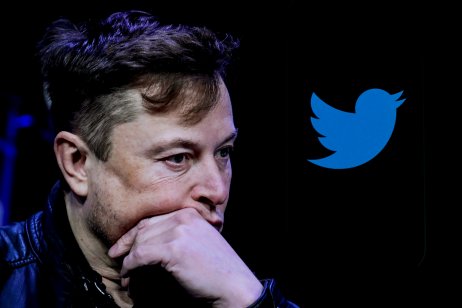 Elon Musk and the logo of Twitter on a mobile phone