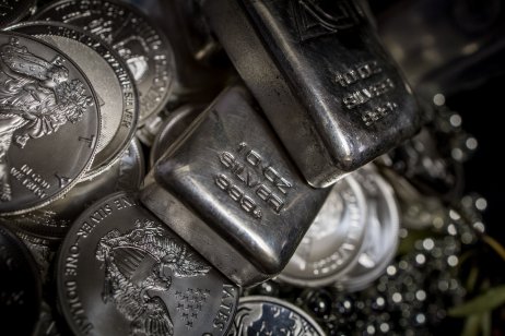 Silver coins and bars on a dark background