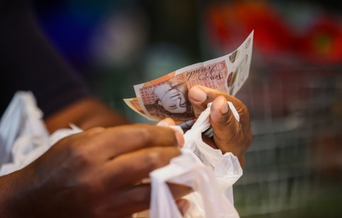 A customer handles cash at a market in the U.K.