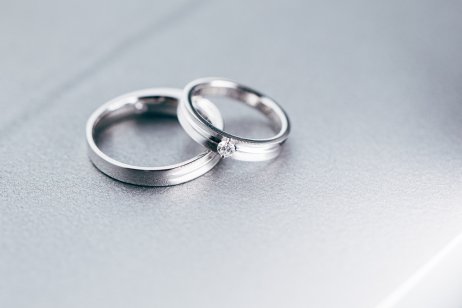 Two platinum wedding bands on a grey background