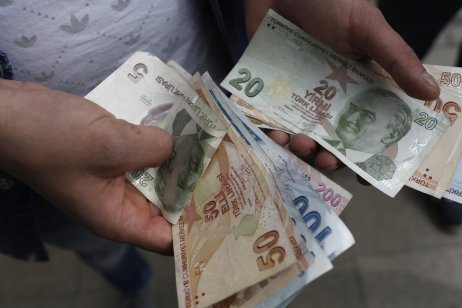 A customer counts Turkish lira bank notes