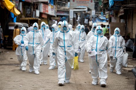 Health workers in full PPE at a slum in Mumbai