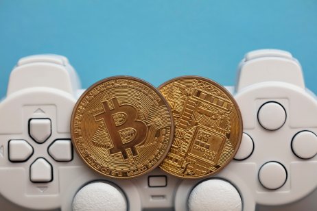 Representation of crypto gaming featuring crypto coins in front of a game controller