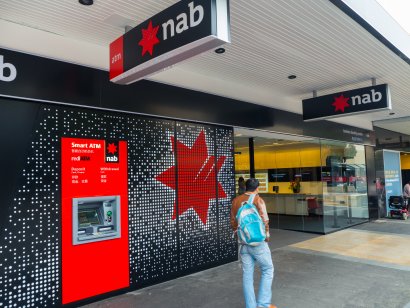 A person passing by NAB’s ATM and branch office in Melbourne, Australia