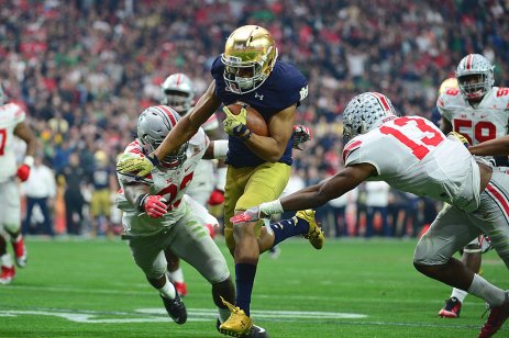 An American Football player runs with the ball 