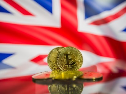 Bitcoin coins in front of a UK flag