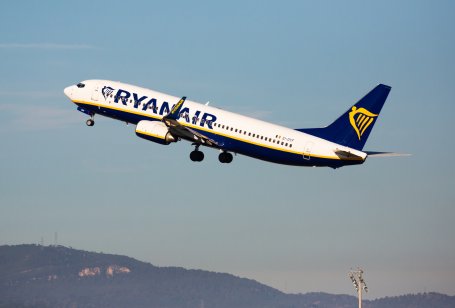 Ryanair plane takes off in the sky with mountains below