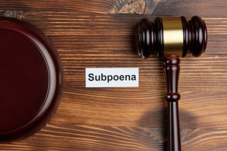 A courtroom gavel lies next to the word ‘subpoena’