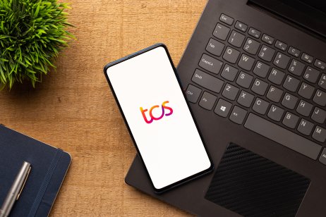 TCS Representative image of TCS logo on a mobile atop a laptop