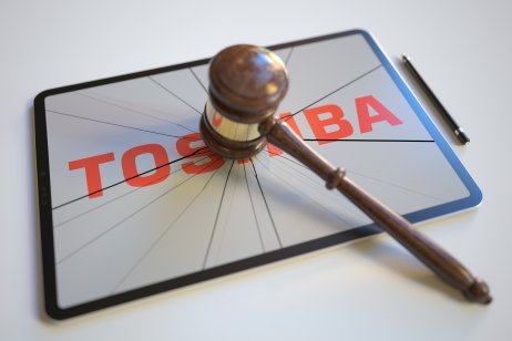 A gavel on a broken tablet screen with the logo of Toshiba